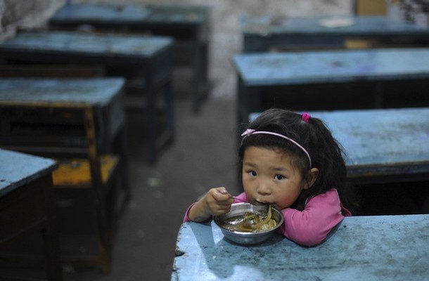 A child of a migrant worker eats her lunch in a classroom at a primary school in Hefei, Anhui province